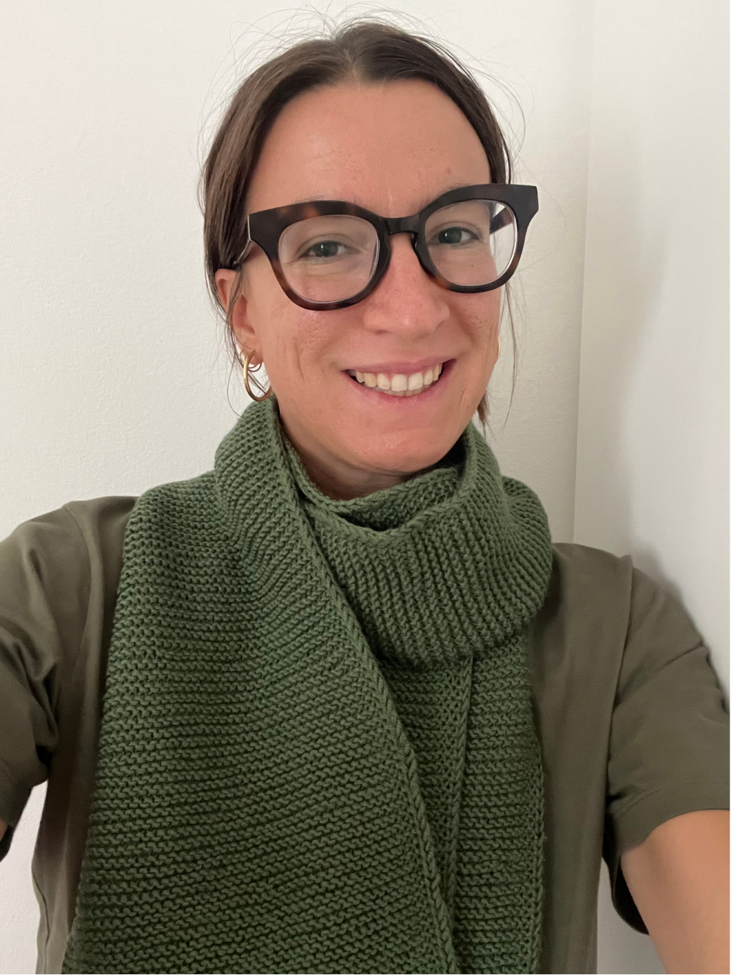 Sciarpa in lana fatta a mano lavorata a maglia, colore verde oliva, indossata per uno stile caldo e naturale