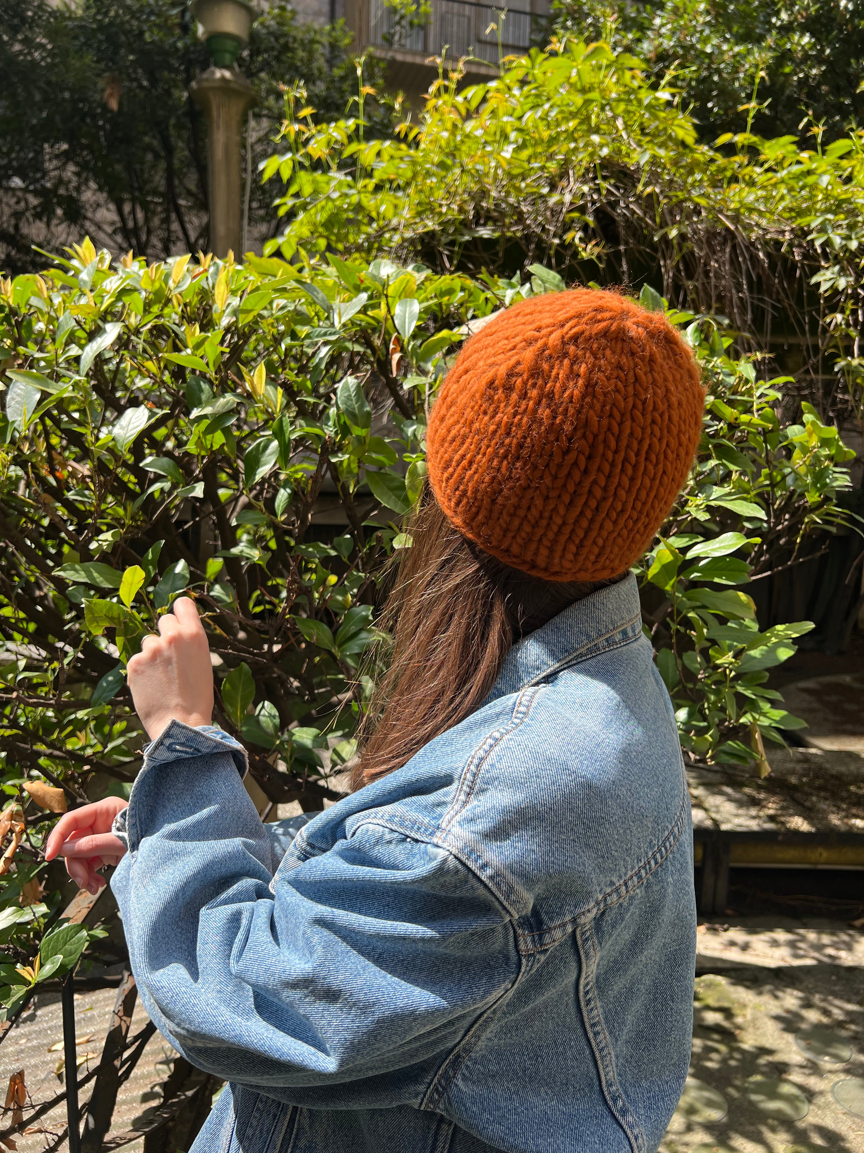Berretto lavorato a maglia a mano con lana naturale, punto compatto e vestibilità morbida, indossato all’esterno